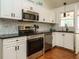 Modern kitchen with stainless steel appliances, white cabinets, and granite countertops at 1487 Kentucky Ave, Sanford, NC 27332