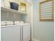 Functional laundry room with washer, dryer, shelving, and patterned accent wall at 1487 Kentucky Ave, Sanford, NC 27332