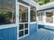 View of the screened-in porch with blue wood and white trim and flooring for outdoor enjoyment at 1487 Kentucky Ave, Sanford, NC 27332