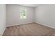 A bright bedroom features neutral walls, carpeting, and a window with views of lush greenery at 150 Ivy Bank Dr, Angier, NC 27501