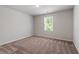 This airy bedroom is bathed in natural light, featuring neutral carpeting and a window with green views at 150 Ivy Bank Dr, Angier, NC 27501