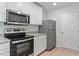 Galley kitchen featuring stainless steel appliances, granite counters, and white cabinets at 150 Ivy Bank Dr, Angier, NC 27501