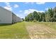 Image displays a very large grassy backyard with green trees in the back at 154 Taverners Ln, Angier, NC 27501