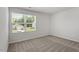 Bright bedroom with neutral carpet, large window, and fresh, neutral paint at 154 Taverners Ln, Angier, NC 27501
