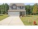 Inviting two-story home featuring a well-maintained lawn, driveway, and a classic facade at 154 Taverners Ln, Angier, NC 27501