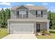 Charming two-story home with a two-car garage, gray siding, and a well-manicured lawn at 154 Taverners Ln, Angier, NC 27501