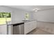 Modern kitchen features an island with a sink and stainless steel dishwasher, seamlessly flowing into the living area at 154 Taverners Ln, Angier, NC 27501