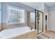 Bathroom featuring a glass enclosed shower, a large window, and a standalone tub at 1624 Struble Cir, Willow Springs, NC 27592