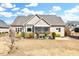 Rear exterior showcasing a charming home with a screened porch and well-maintained landscaping at 1624 Struble Cir, Willow Springs, NC 27592