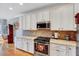 Kitchen boasts extensive granite countertops, stainless steel appliances, and white cabinetry at 1624 Struble Cir, Willow Springs, NC 27592