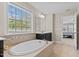 Bright bathroom with large tub and dual vanity sink offers natural light through the window at 2120 Rainy Lake St, Wake Forest, NC 27587