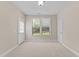 Bright bedroom features neutral walls, plush carpeting, and a view of the outdoor greenery at 2120 Rainy Lake St, Wake Forest, NC 27587