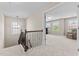 Upstairs hallway with decorative railing and bonus room with a comfortable chair at 2120 Rainy Lake St, Wake Forest, NC 27587