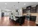Open concept kitchen with dark cabinets, stainless appliances, granite counters, and hardwood floors at 2120 Rainy Lake St, Wake Forest, NC 27587