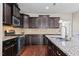 A kitchen featuring granite countertops, stainless steel appliances, and dark wood cabinets at 2120 Rainy Lake St, Wake Forest, NC 27587