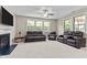 A spacious living room with a fireplace, lots of seating, and large windows providing ample natural light at 2120 Rainy Lake St, Wake Forest, NC 27587