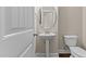 A clean powder room with a pedestal sink, a round mirror, and a tiled floor at 2120 Rainy Lake St, Wake Forest, NC 27587