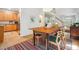 Bright dining area with rustic wooden table, four chairs, colorful rug and view into the kitchen and living area at 219 W Columbia Pl, Chapel Hill, NC 27516