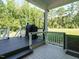 Relaxing back deck with a black grill, and views of green trees and a grassy lawn at 221 Stella Way, Cameron, NC 28326