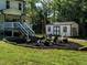 Inviting backyard featuring a fire pit surrounded by Adirondack chairs, adjacent to a cute white storage building at 221 Stella Way, Cameron, NC 28326