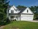 Charming two-story home boasts a manicured lawn, attached two car garage, and cozy front porch perfect for relaxing at 221 Stella Way, Cameron, NC 28326