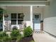Cozy front porch seating area with hanging flower baskets, a 'welcome' sign, and a light blue front door at 221 Stella Way, Cameron, NC 28326