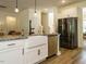Well-equipped kitchen features a stainless steel dishwasher, refrigerator and a granite countertop with white cabinetry at 221 Stella Way, Cameron, NC 28326