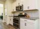 Modern kitchen features stainless steel appliances, granite countertops, and stylish white cabinetry at 221 Stella Way, Cameron, NC 28326