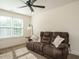 Comfortable living room featuring a plush sofa, ceiling fan, and large window providing natural light at 221 Stella Way, Cameron, NC 28326