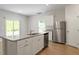 Bright kitchen features white cabinets, stainless steel appliances, granite countertops and a sliding glass door at 224 Ivy Bank Dr, Angier, NC 27501