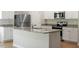 Well-lit kitchen boasts granite countertops, stainless steel appliances, white cabinets, and a kitchen island at 224 Ivy Bank Dr, Angier, NC 27501