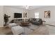 Inviting living room featuring a ceiling fan, gray sofa, and stylish decor at 224 Ivy Bank Dr, Angier, NC 27501