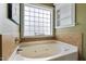 Bathroom featuring a soaking tub with jets, tile walls and flooring, and a window at 236 Emma Ct, Linden, NC 28356