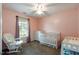 This pink Bedroom features a rocking chair, blinds on the window, and a crib at 236 Emma Ct, Linden, NC 28356