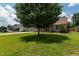 Beautifully landscaped front yard featuring a mature tree, lush lawn, and charming curb appeal at 236 Emma Ct, Linden, NC 28356