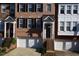 Up close exterior of a charming brick townhome with black shutters and a one-car garage at 2507 Princewood St, Raleigh, NC 27612