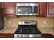 Close up of the kitchen stainless steel oven, stovetop, microwave and granite counter tops at 2507 Princewood St, Raleigh, NC 27612