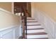 Interior view of a wooden staircase with white risers, detailed trim, and a wooden banister at 2507 Princewood St, Raleigh, NC 27612