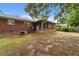 This exterior view shows the brick house, screened porch, and a large, shaded backyard at 2512 Mckinney St, Burlington, NC 27217