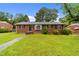 Charming red brick home with a well-maintained lawn and mature trees, offering a welcoming curb appeal at 2512 Mckinney St, Burlington, NC 27217