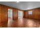Spacious living room with wood-paneled walls, hardwood floors, and natural light at 2512 Mckinney St, Burlington, NC 27217