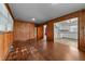Another view of living room with knotty wood paneling and hardwood floors open to kitchen at 2512 Mckinney St, Burlington, NC 27217