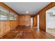 Bright living room with wood-paneled walls and hardwood floors offers plenty of natural light at 2512 Mckinney St, Burlington, NC 27217