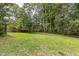 Wide view of the lawn in the large, tree lined backyard showing plenty of space for outdoor enjoyment at 2712 Pebblebrook Dr, Sanford, NC 27330