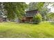 Backyard with mature trees, wooden deck with stairs, and screened-in porch on home at 2712 Pebblebrook Dr, Sanford, NC 27330