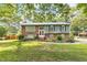 Charming two-story home with a mix of brick and green wood, surrounded by mature trees and green lawns at 2712 Pebblebrook Dr, Sanford, NC 27330