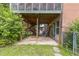 View beneath the back porch, showing access to storage and yard with brick foundation and greenery at 2712 Pebblebrook Dr, Sanford, NC 27330