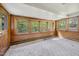 Bright sunroom features wood paneling, multiple windows, and carpeted floors for a cozy space at 2715 E Geer St, Durham, NC 27704