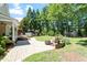 Serene backyard with a paved patio, fire pit, hot tub, lush greenery and mature trees at 312 Flint Point Ln, Holly Springs, NC 27540