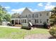 Spacious backyard with covered porch, multiple windows, and a hot tub for outdoor relaxation at 312 Flint Point Ln, Holly Springs, NC 27540